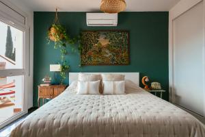 a bedroom with a large bed with a green wall at Villa Maravilla in Lloret de Mar