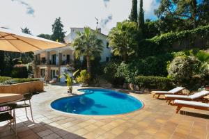 a swimming pool in a patio with a table and chairs at Villa Maravilla in Lloret de Mar