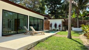 a house with two chairs sitting on a patio at Samma Villas - Onyx Villa - 1 BDR & Private Pool in Ko Phangan