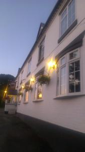 a white house with windows and lights on it at The Railway Inn in Forden