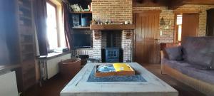 a living room with a coffee table and a fireplace at Vakantiewoning Zoetebeek in Oudenaarde
