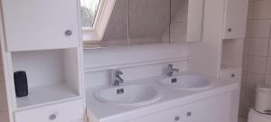 a white bathroom with two sinks and a mirror at Vakantiewoning Zoetebeek in Oudenaarde +20 photos