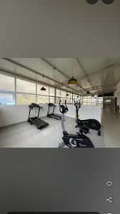 a gym with three treadmills and cardio machines at Sanvi studio rooms in Bangalore