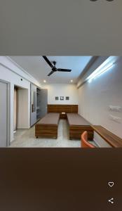 a bedroom with two beds and a ceiling fan at Sanvi studio rooms in Bangalore +4 photos