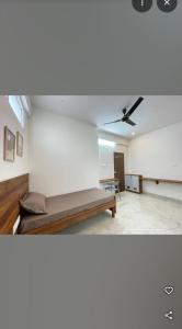 a room with a bed and a ceiling fan at Sanvi studio rooms in Bangalore