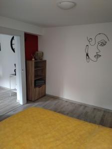 a room with a white wall and a yellow rug at Les gîtes d'Esika in Rimbach-près-Masevaux +3 photos