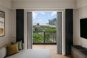 a bedroom with a bed and a balcony with a view at The Laurus, a Luxury Collection Resort, Singapore in Singapore