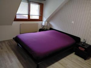 a bedroom with a purple bed in a room at Les gîtes d'Esika in Rimbach-près-Masevaux