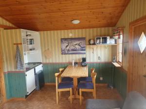 a kitchen with a wooden table and blue chairs at Villaberg in Arvika