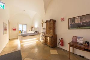 een woonkamer met een wastafel en een houten kast bij Benediktushaus im Schottenstift in Wenen