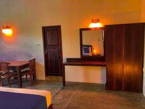 a bedroom with a desk and a mirror and a table at Red lettter hotel in Nikawatawana