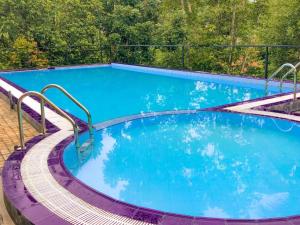 a large swimming pool with blue water and stairs at Red lettter hotel in Nikawatawana
