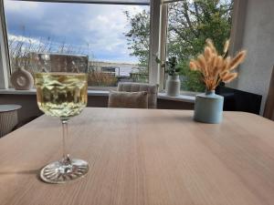 a glass of wine sitting on top of a table at Het Goudvinkennestje in Matsloot