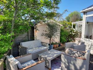 a patio with chairs and a table and a bench at Het Goudvinkennestje in Matsloot +19 photos