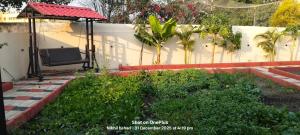 a garden with a chair and a gazebo at aasara resort in Bhopal