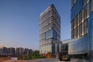 a tall glass building in front of a city at Four Points by Sheraton Tianshui in Tianshui