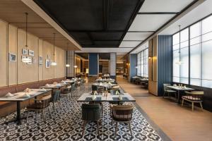 a restaurant with tables and chairs and windows at Four Points by Sheraton Tianshui in Tianshui