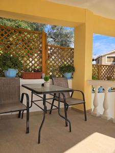 a patio with a table and chairs and a fence at Dimitris House Petriti in Petrití