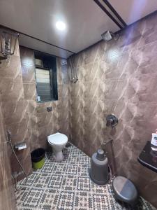a bathroom with a toilet and a stone wall at Hotel Sunshine Airport in Mumbai +120 photos