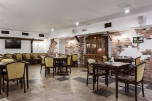 ein Esszimmer mit Tischen und Stühlen und einer Backsteinwand in der Unterkunft Apart Hotel Tomo FREE PARKING in Riga