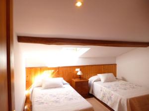 a bedroom with two beds and a light at Los campos in Hontoria