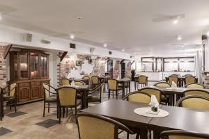 ein Restaurant mit Tischen und Stühlen in einem Raum in der Unterkunft Apart Hotel Tomo FREE PARKING in Riga