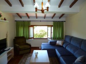 a living room with a blue couch and green curtains at Los campos in Hontoria