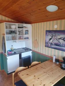 a kitchen with a table and a stove and a refrigerator at Villaberg in Arvika