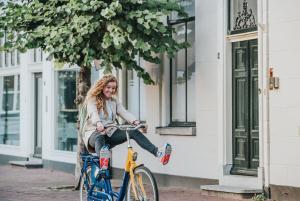 a woman riding a bike down a street at Stationsstraat 4H in Amersfoort