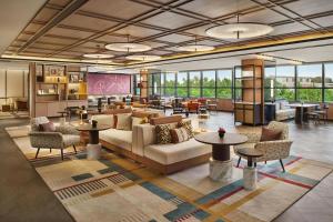 a lobby with a couch and chairs and tables at Renaissance Shanghai Hongqiao in Shanghai