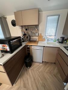 a small kitchen with a microwave and a sink at Mobile-home in Gassin +4 photos