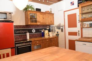 una cucina con armadi in legno e frigorifero rosso di Alte Landjägerei Aukrug a Aukrug
