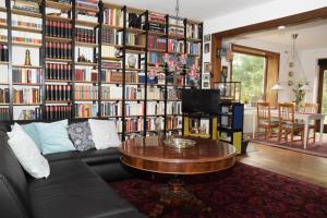 uma sala de estar com um sofá e uma grande parede de livros em Alte Landjägerei Aukrug em Aukrug