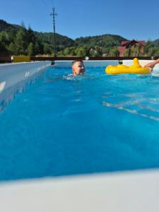 a young boy swimming in a swimming pool at Садиба Магнолія in Tukhlya