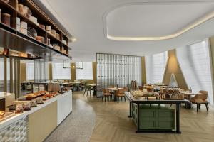 a restaurant with a cafeteria with tables and chairs at Courtyard by Marriott Yibin in Yibin