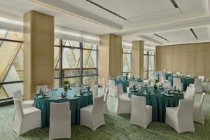 a conference room with tables and white chairs at Courtyard by Marriott Yibin in Yibin