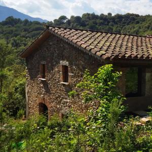 an old stone house with a tile roof at Masia Casa Nova de n'Illa in Montseny