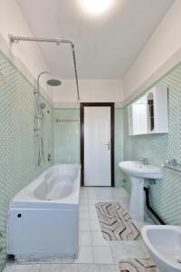 a bathroom with a white tub and a sink at Easy Downtown Inn in Marghera
