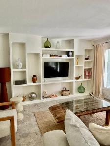 a living room with a flat screen tv and shelves at Luxury family villa with large pool, garden & outdoor dining near beach, Domaine l'Oiseau Bleu in Sainte-Maxime in Sainte-Maxime