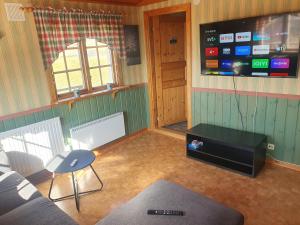 a living room with a couch and a flat screen tv at Villaberg in Arvika