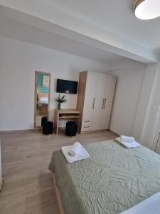 a bedroom with a bed and a desk and a television at Rooms Čapo Rab in Palit