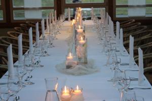 a long table with candles and wine glasses on it at Hotel Dreimädelhaus in Espelkamp-Mittwald