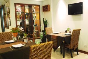 a dining room with two tables and chairs and a television at Baan Sukhumvit Soi 18 in Bangkok