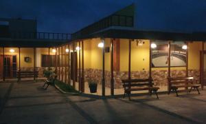 un grupo de bancos fuera de un edificio por la noche en Paradisse, en Huacho