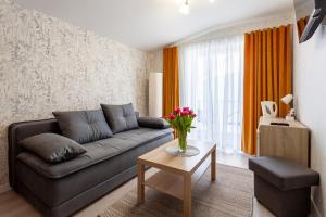 a living room with a couch and a table at POKOJE APARTAMENTY ANASTAZJA in Grzybowo