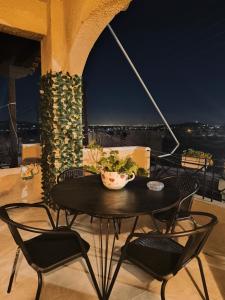 a black table and chairs on a balcony at night at Christina's house in Kipséli
