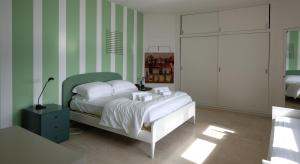 a bedroom with a bed with green and white stripes at Villa Coccodrilla in Toscolano Maderno