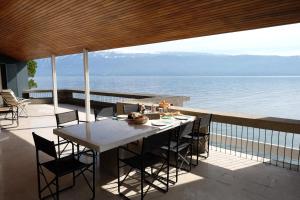 einen Tisch und Stühle auf einem Balkon mit Meerblick in der Unterkunft Villa Coccodrilla in Toscolano-Maderno