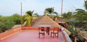 a table and chairs on top of a building at Oasis Palmarin in Palmarin