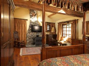 una camera da letto con un letto e una TV in una stanza di Summerhill Cottage a Windermere
